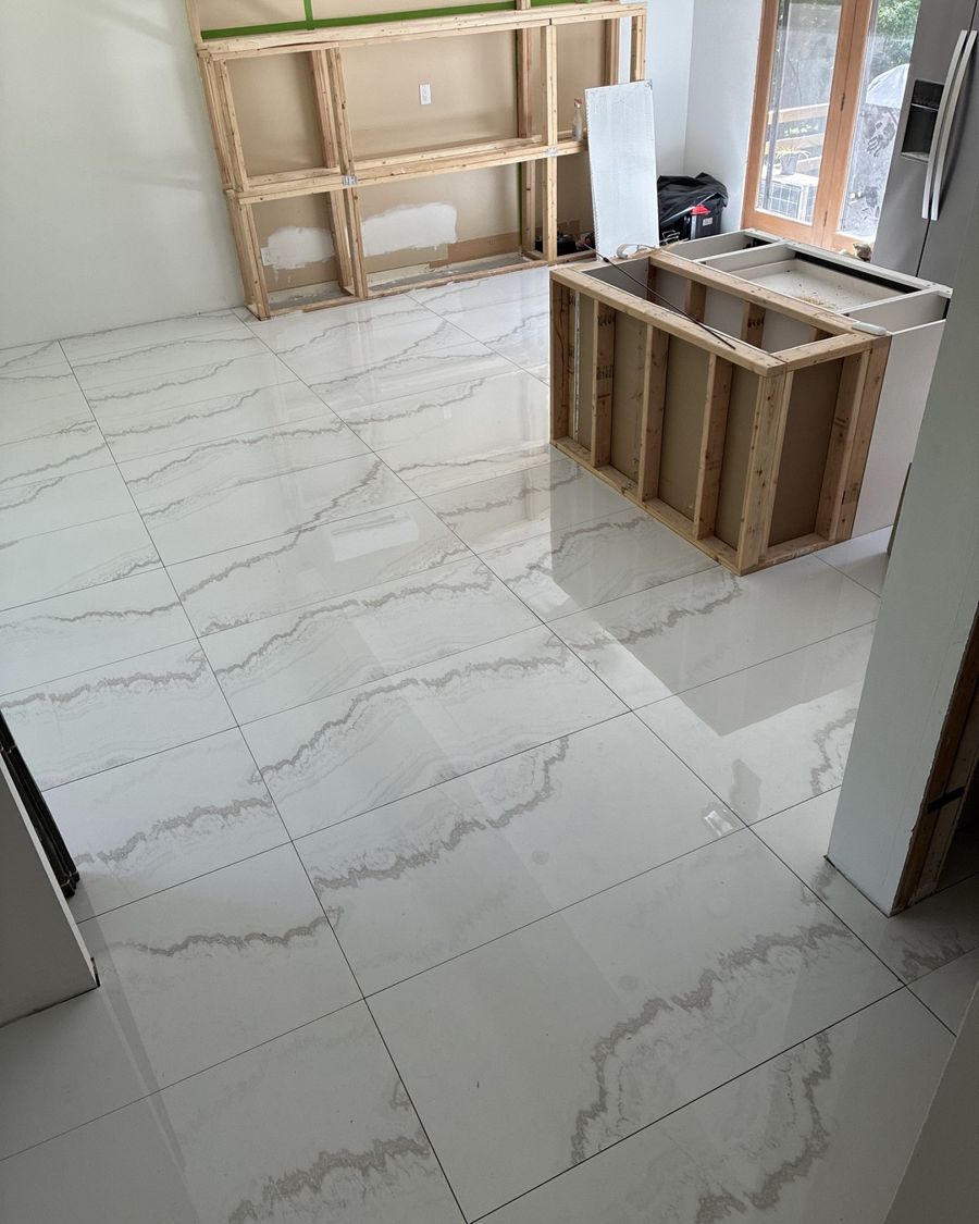 Large-format white marble-look tile floor freshly installed.